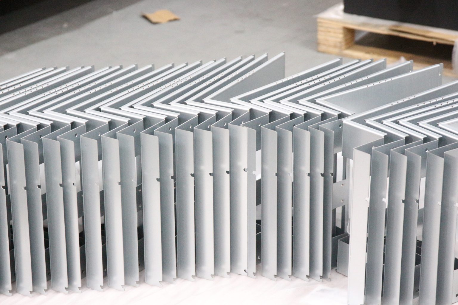 Batch of identical bent sheet metal brackets produced at STARWAY MFG GROUP, showing repeatable production output