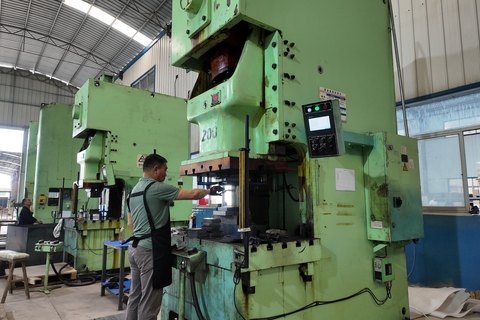 Operator running a stamping press at Jingdezhen STARWAY