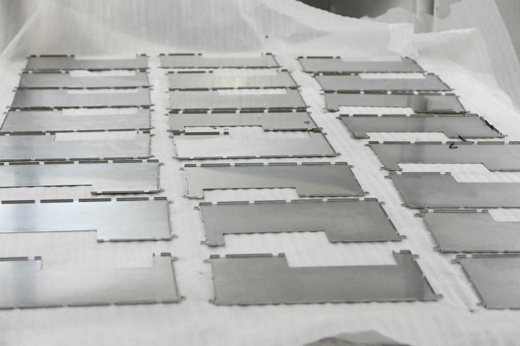 Nested laser-cut sheet metal parts still held in the skeleton after cutting