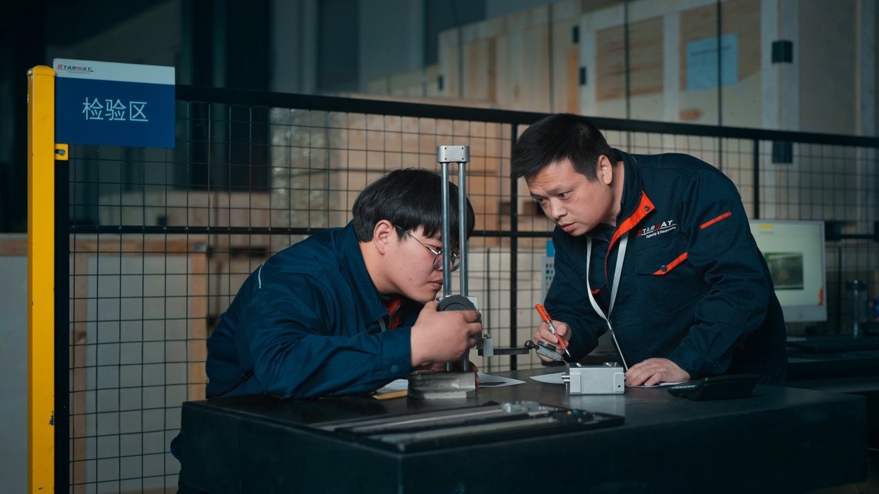 Two STARWAY MFG GROUP inspectors measuring a custom metal part with a height gauge in the inspection area