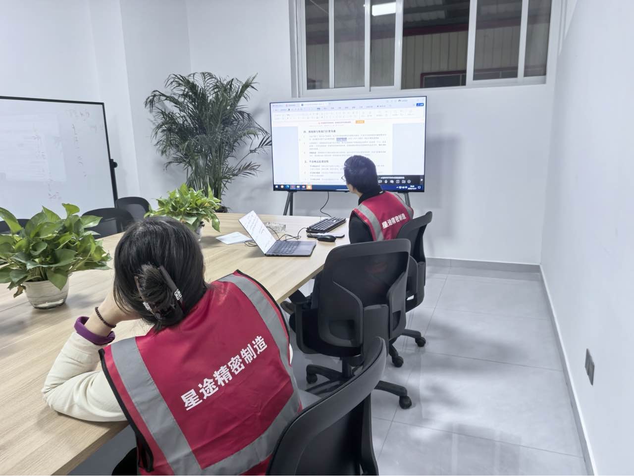 Production management staff reviewing work on a display screen in the STARWAY Jingdezhen office