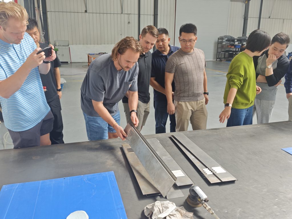 Customer inspecting fabricated sheet metal parts with the STARWAY factory team